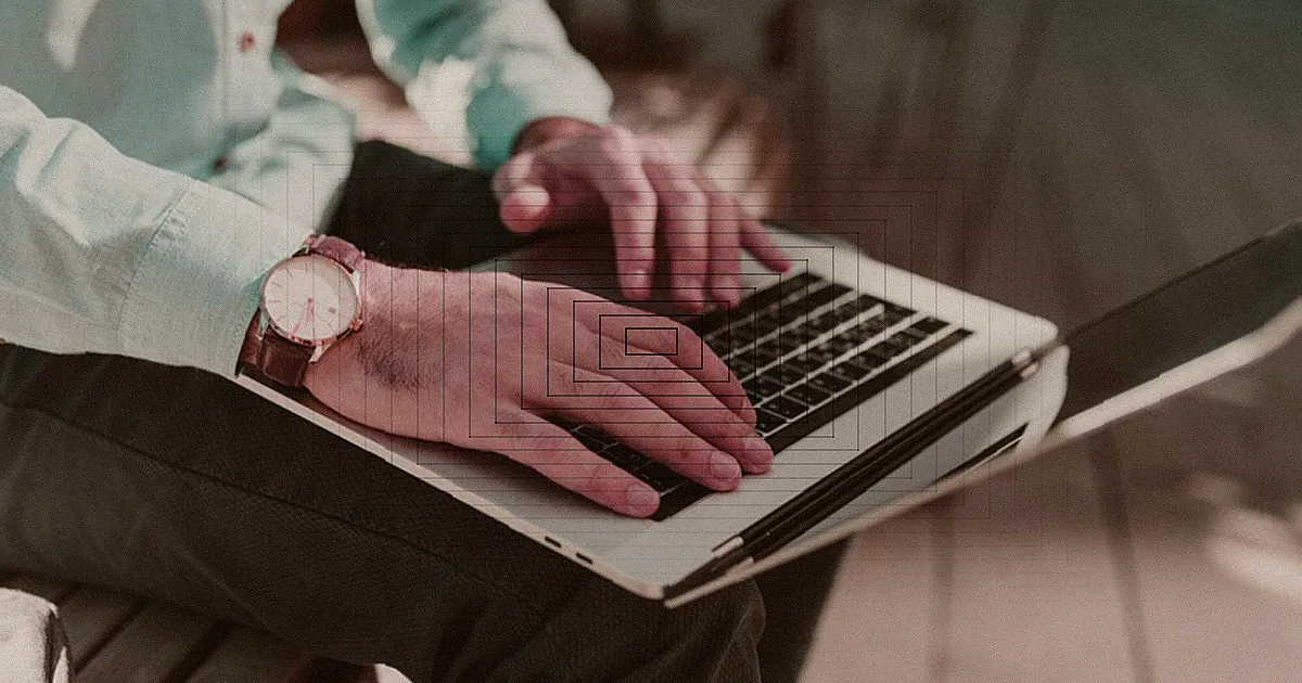 Woman working on a laptop in a cozy home office, smiling at the camera. — Foto: Helena Lopes / Pexels