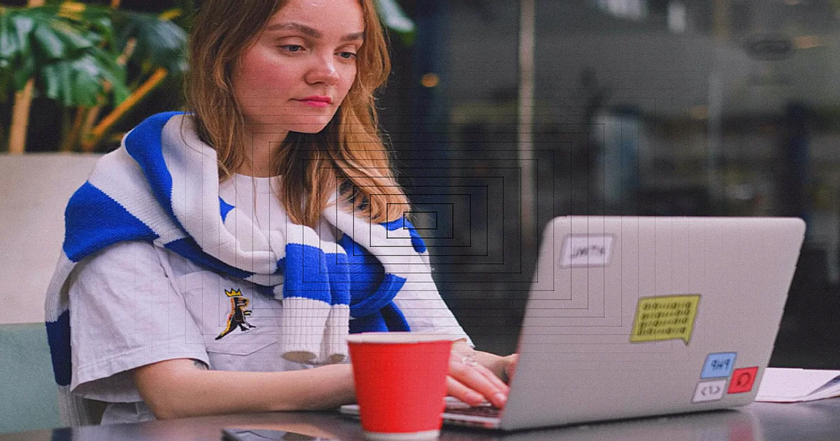 A young woman in a red dress holding a laptop outdoors, looking thoughtful. — Foto: Anna Shvets / Pexels