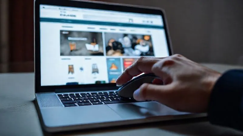 A photorealistic image of a sleek, modern e-commerce website interface displayed on a laptop, with a hand hovering over a mouse. The interface is clean, intuitive, and visually appealing, emphasizing excellent User Experience (UX) design. Cinematic lighting, sharp focus on the screen, 8K hyper-detailed, professional photography.