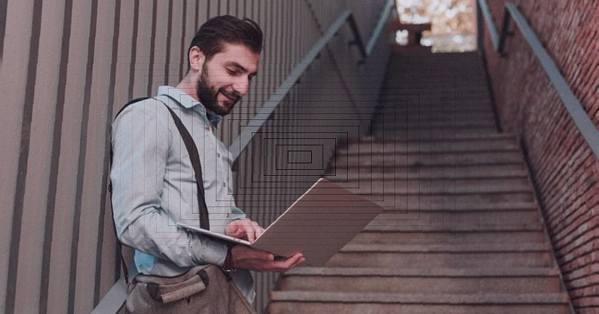 Adult man with a beard and mustache working on his laptop outdoors at night. — Foto: Aathif Aarifeen / Pexels