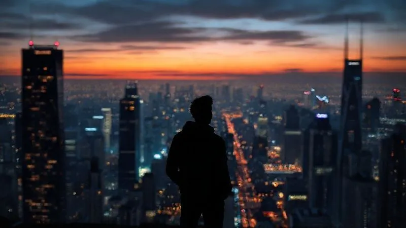 A photorealistic image of a futuristic cityscape at dawn, with subtle glowing lines connecting buildings, symbolizing a vast, interconnected blockchain network. In the foreground, a silhouetted figure of a person (a freelancer) stands confidently, looking towards the horizon of possibilities. Cinematic lighting, sharp focus on the figure and immediate foreground, depth of field blurring the distant city. 8K hyper-detailed, professional photography, shot on a high-end DSLR.