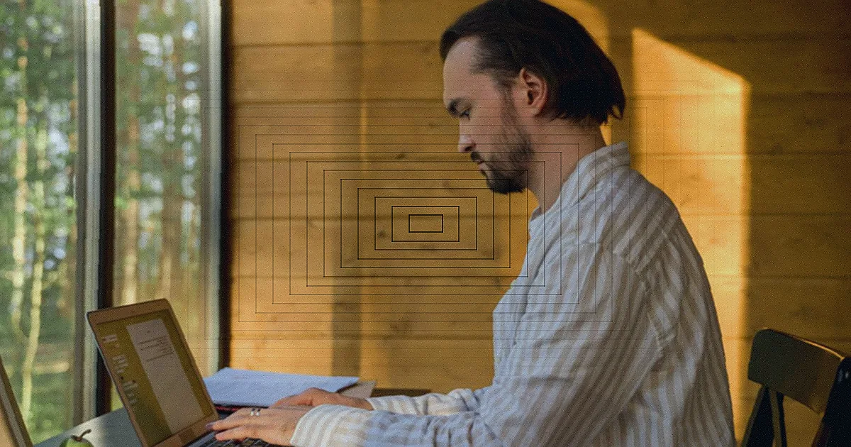 A cheerful man sitting under a tree working on a laptop in a serene rural setting. — Foto: Matheus Bertelli / Pexels